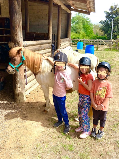 Groupe d'enfants heureux au poney club de Bully